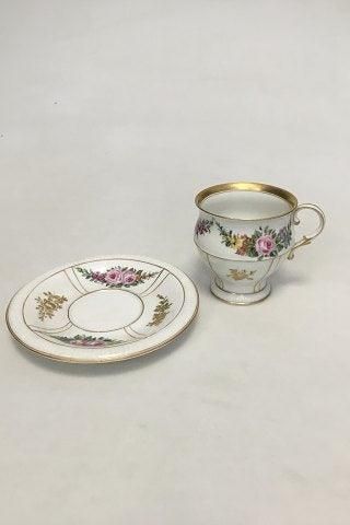 Antique Bing & Grøndahl Cup and Saucer in gilt and Polychrome over glaze with floral motive.