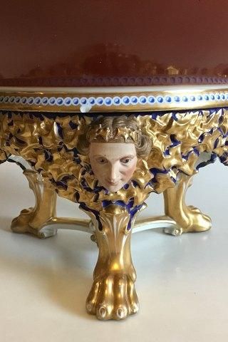 Antique Bing og Grondahl Punch Bowl on stand of porcelain, decorated in red, blue and gold. Stand with modeled leaves, faun and buck heads, standing on three animal paws style of Heinrich Hansen
