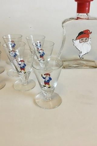 Antique Christmas carafe with 8 small glasses. Decorated with Santa Claus. The Carafe is spherical grinded at the bottom and labeled 
