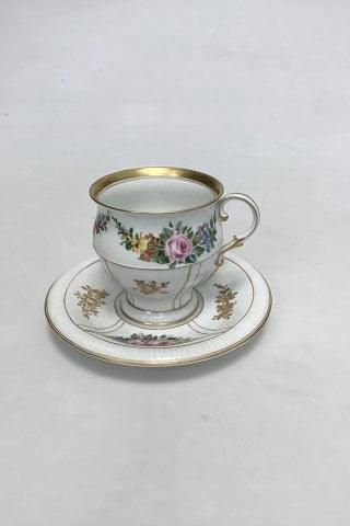 Antique Bing & Grøndahl Cup and Saucer in gilt and Polychrome over glaze with floral motive.