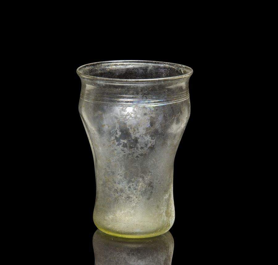 Antique A Roman glass beaker with indented sides