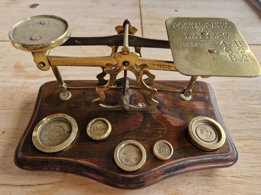 Antique wood and brass postal scale. Includes weights