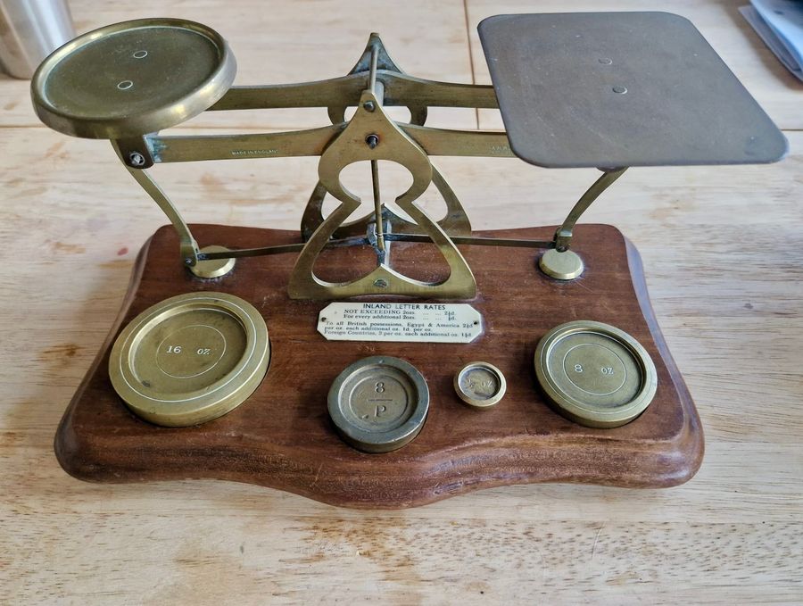 Antique wood and brass postal scale. Includes weights.