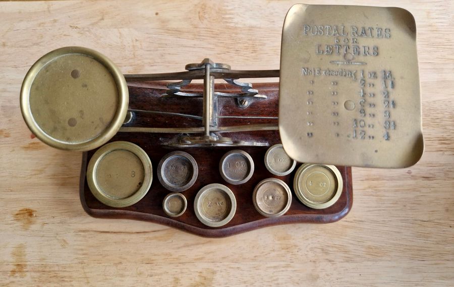 Antique wood and brass postal scale. Includes weights.