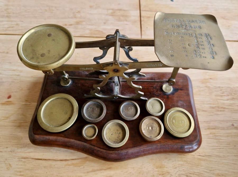 Antique Antique wood and brass postal scale. Includes weights.