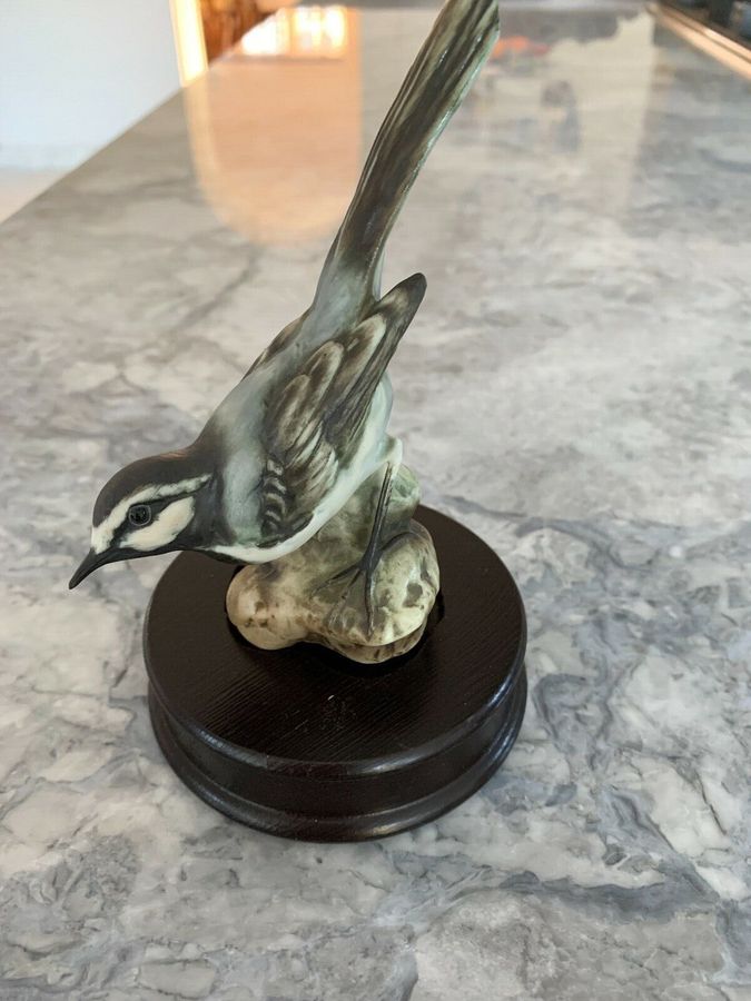 A vintage West Germany kaiser porcelain bird figurine sit on a wooden plinth