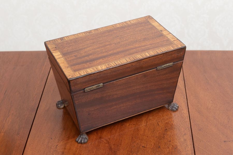 Antique A fine Georgian mahogany tea caddy on brass paw feet.